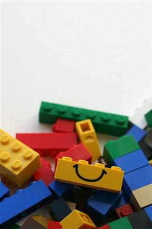 一堆色彩鲜艳的建筑砖块，其中一个上面有一个微笑